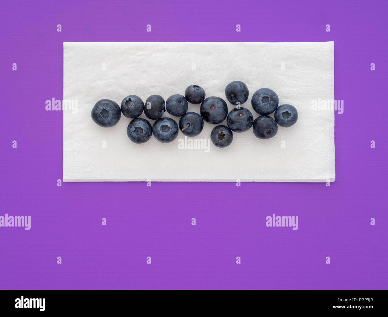 Gesunde superfood Blaubeeren auf weißem Papier Servietten, Serviette, auf lila Hintergrund. Mit Copyspace. Stockfoto