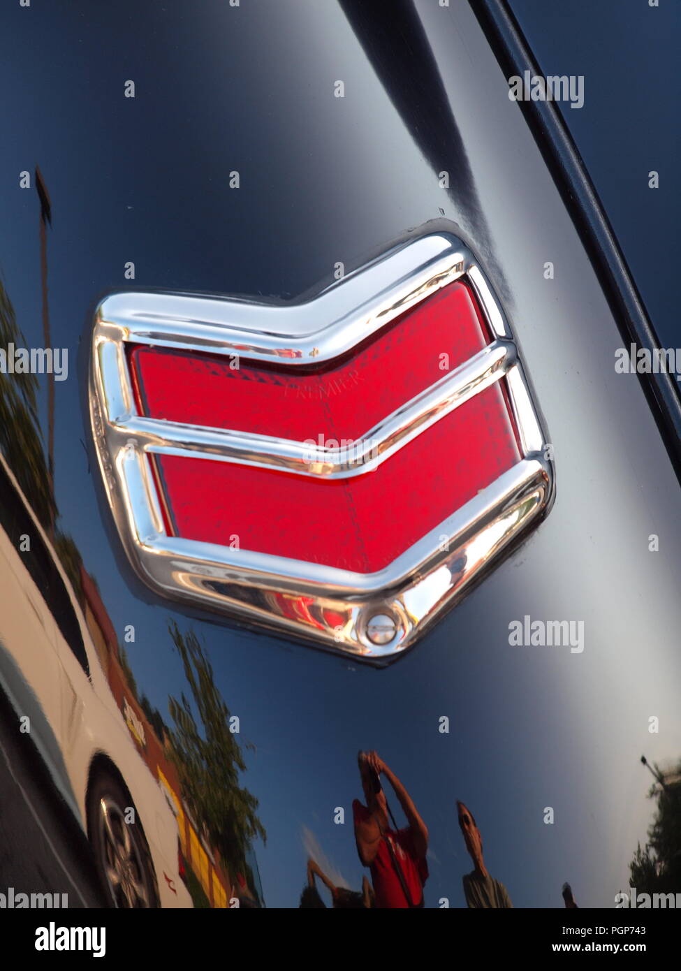 Schlußleuchte auf einem 1940er Ford Coupe bei einer lokalen NJ Car Show mit einer Reflexion des Fotografen und einem weißen Mustang. Stockfoto