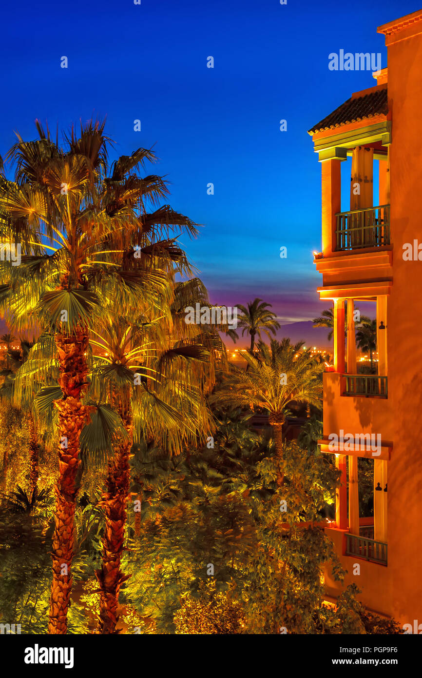 Marrakesch Marokko Luxushotel Balkone und Oasis Palm Garden bei Nacht mit dramatischen Landschaft Beleuchtung. Tief blauen Himmel. Marokkanischen Farben. Stockfoto