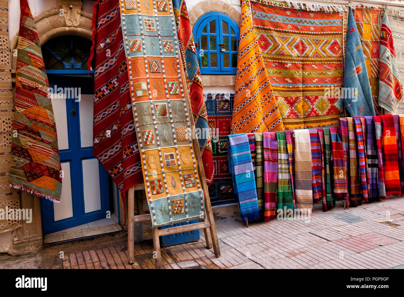 Marokkanische Shop mit bunten Teppichen und Teppichen auf Anzeige außen hängen an den Wänden. Ort: Essaouira, Marokko Stockfoto