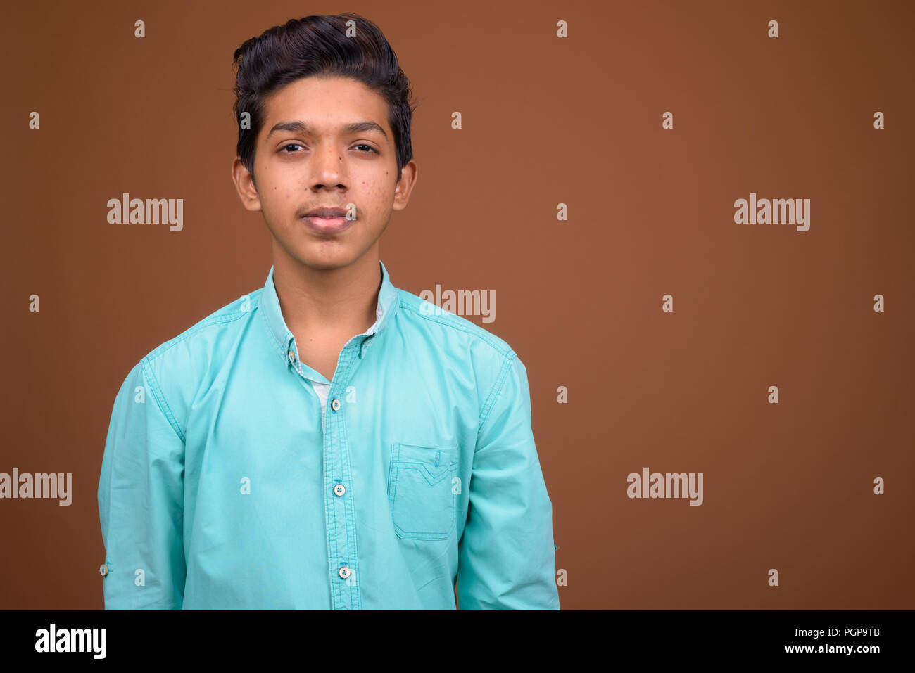 Jungen trägt blaue Shirt suchen smart gegen Braun Stockfoto