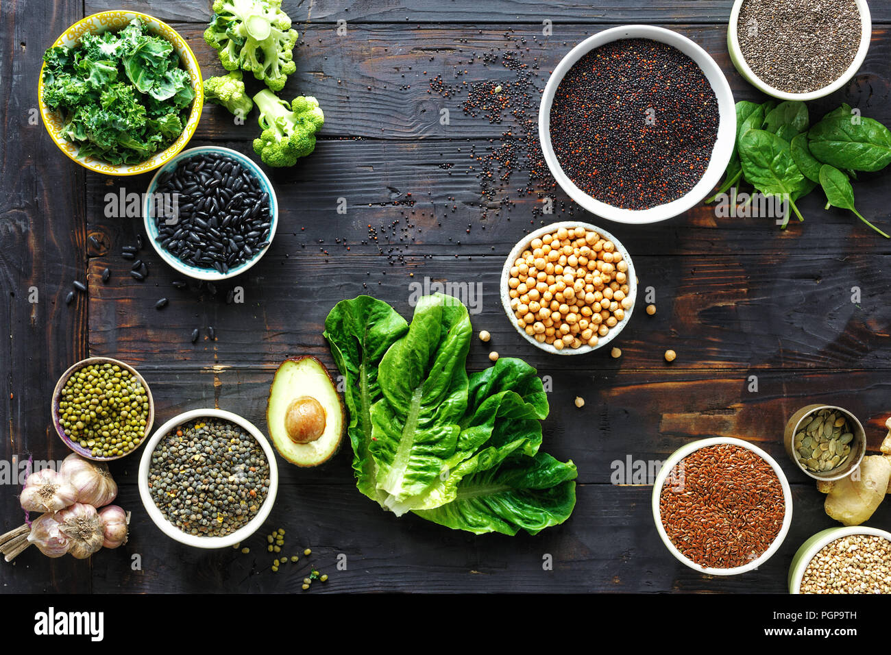 Rohen Samen, Getreide, Bohnen, Superfoods und grünes Gemüse auf dunklen Holztisch Draufsicht. vegetarisch oder Diät Lebensmittel Konzept Stockfoto