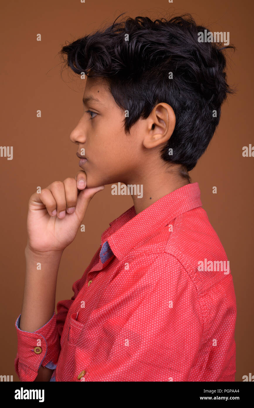 Jungen tragen Smart Casual Kleidung gegen Braun bac Stockfoto