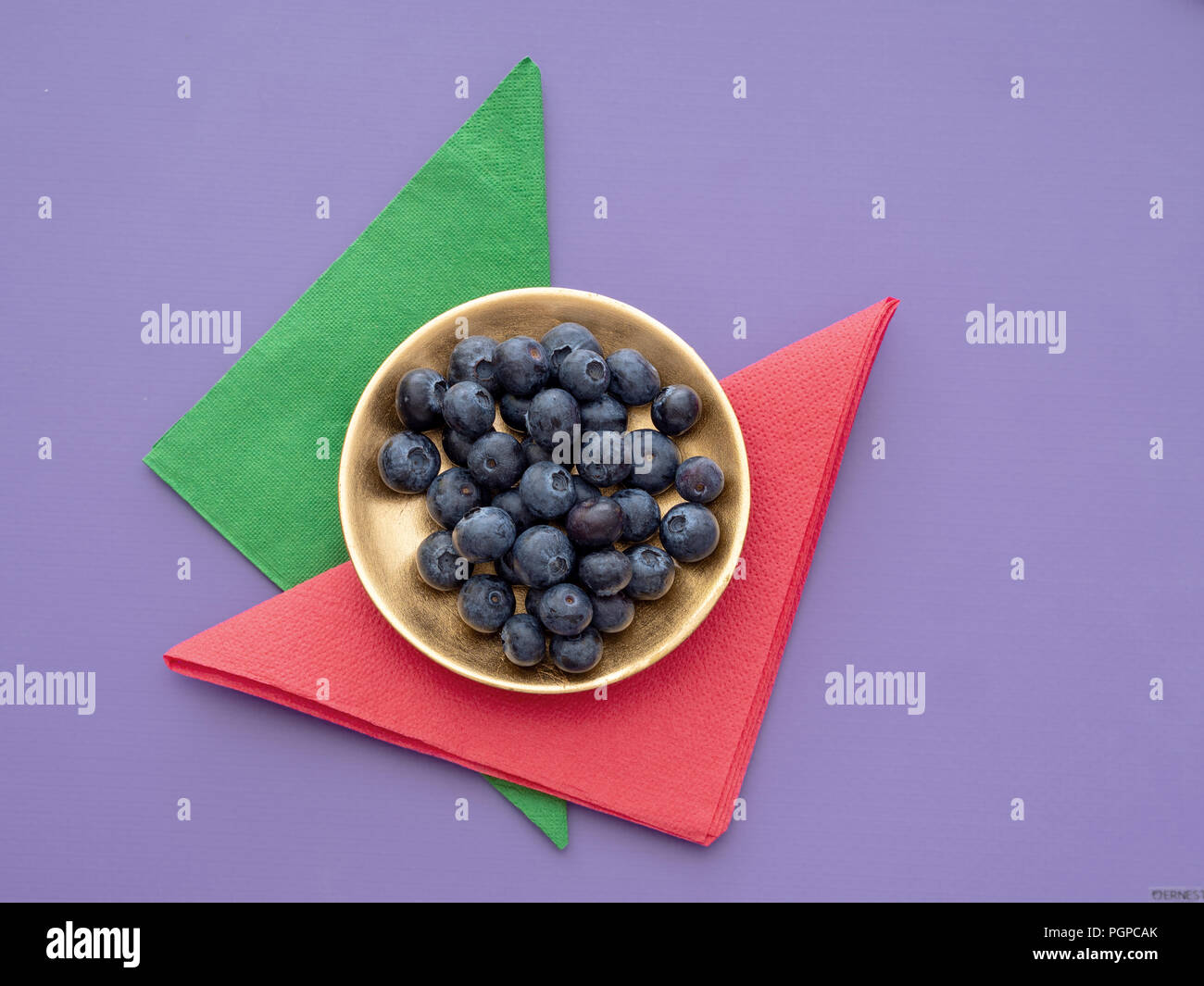 Gesunde superfood Blaubeeren auf bunten Hintergrund mit Papier Servietten, Servietten und vergoldet. Stockfoto