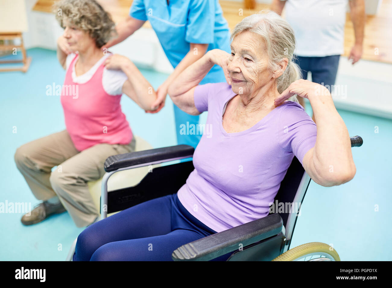 Senioren tun Reha Gymnastik für den Rücken in der Physiotherapie Stockfoto