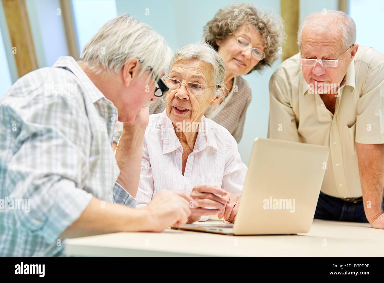 Senior Group voller Neugier zusammen auf dem Laptop und Internet Kommunikation Stockfoto