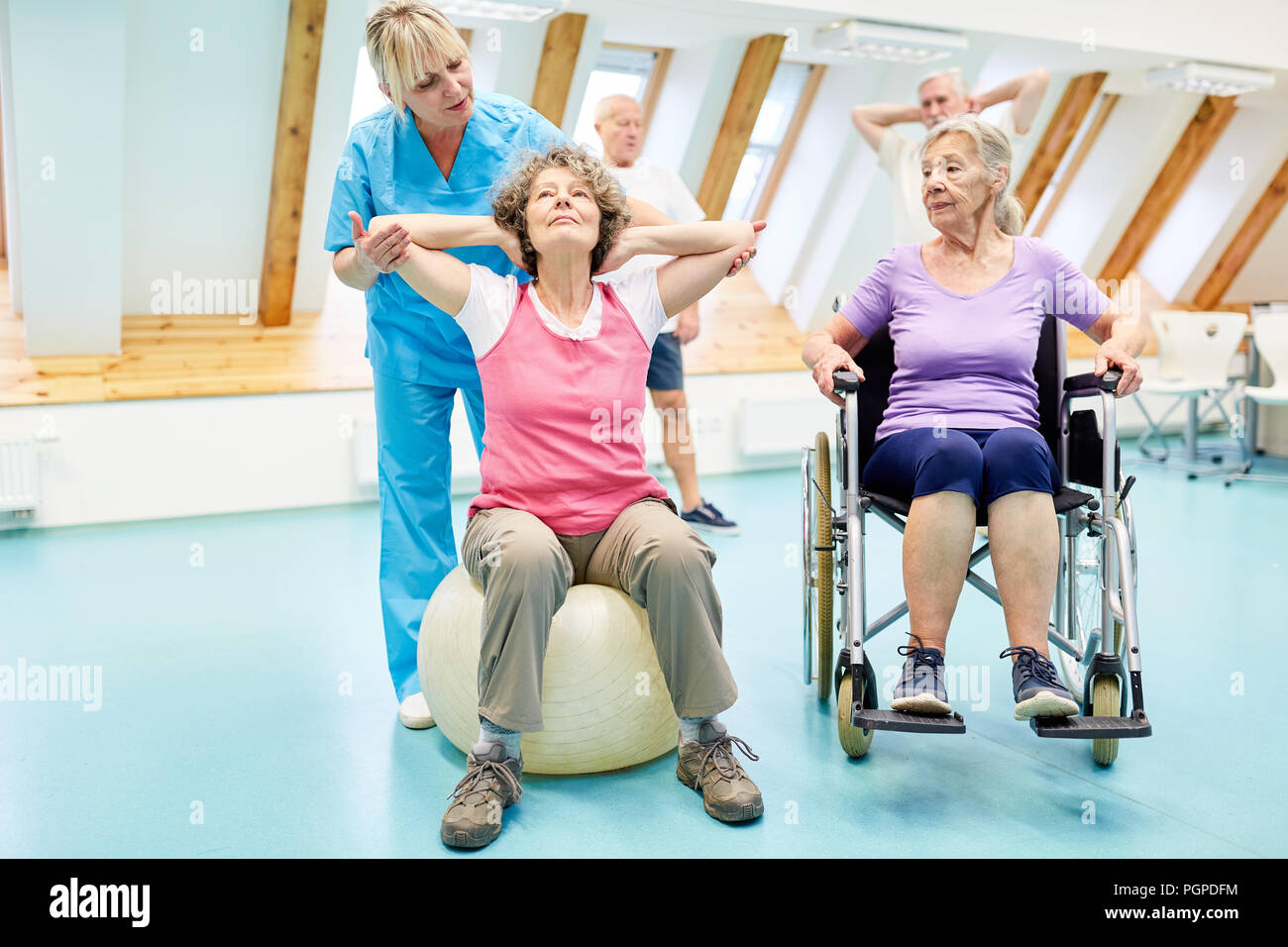 Physiotherapeut hilft Senioren mit rehab Übungen in der Physiotherapie Kurs Stockfoto