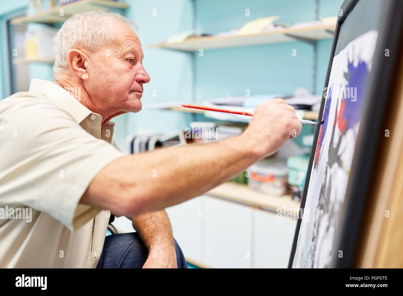 Senior mit Demenz ein Bild malt in der kreativen Malerei Therapie in der Seniorenresidenz Stockfoto