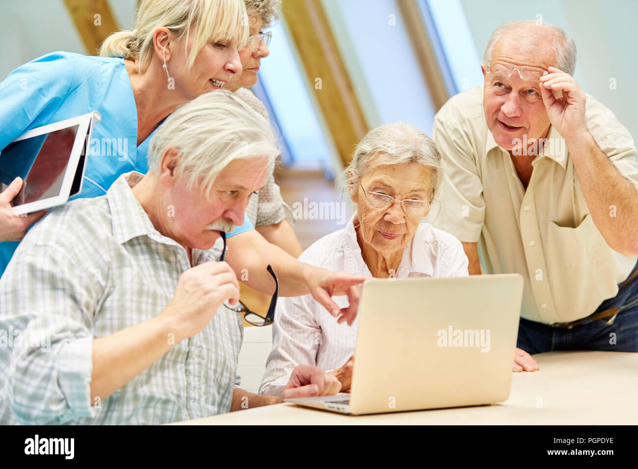 Gruppe von Senioren ist Lernen mit Laptop im Computer Kurs unterstützt  durch Betreuer Stockfotografie - Alamy