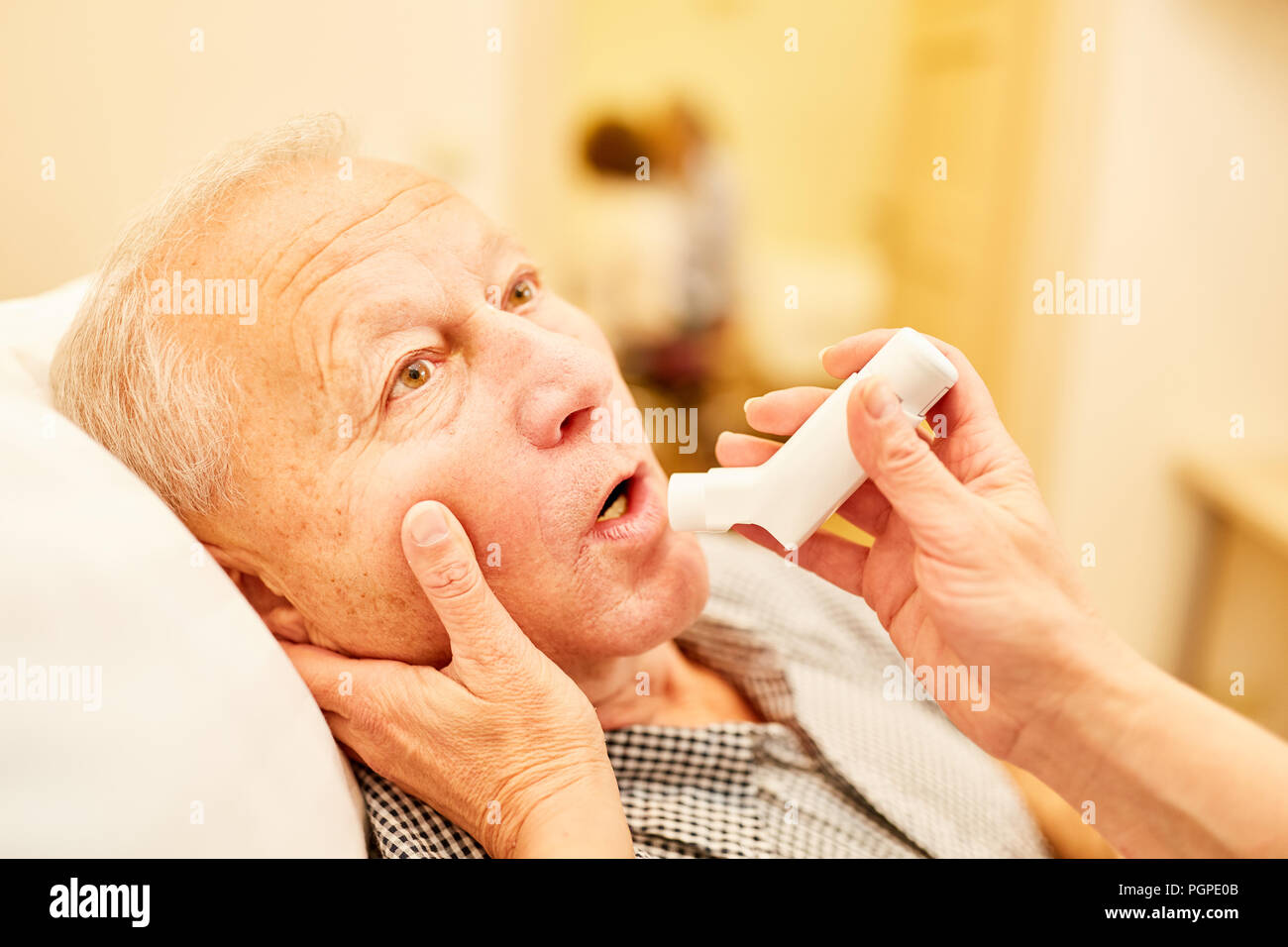 Alter Mann mit Atemnot erhält sofortige Hilfe mit dem Inhalator im Pflegeheim Stockfoto