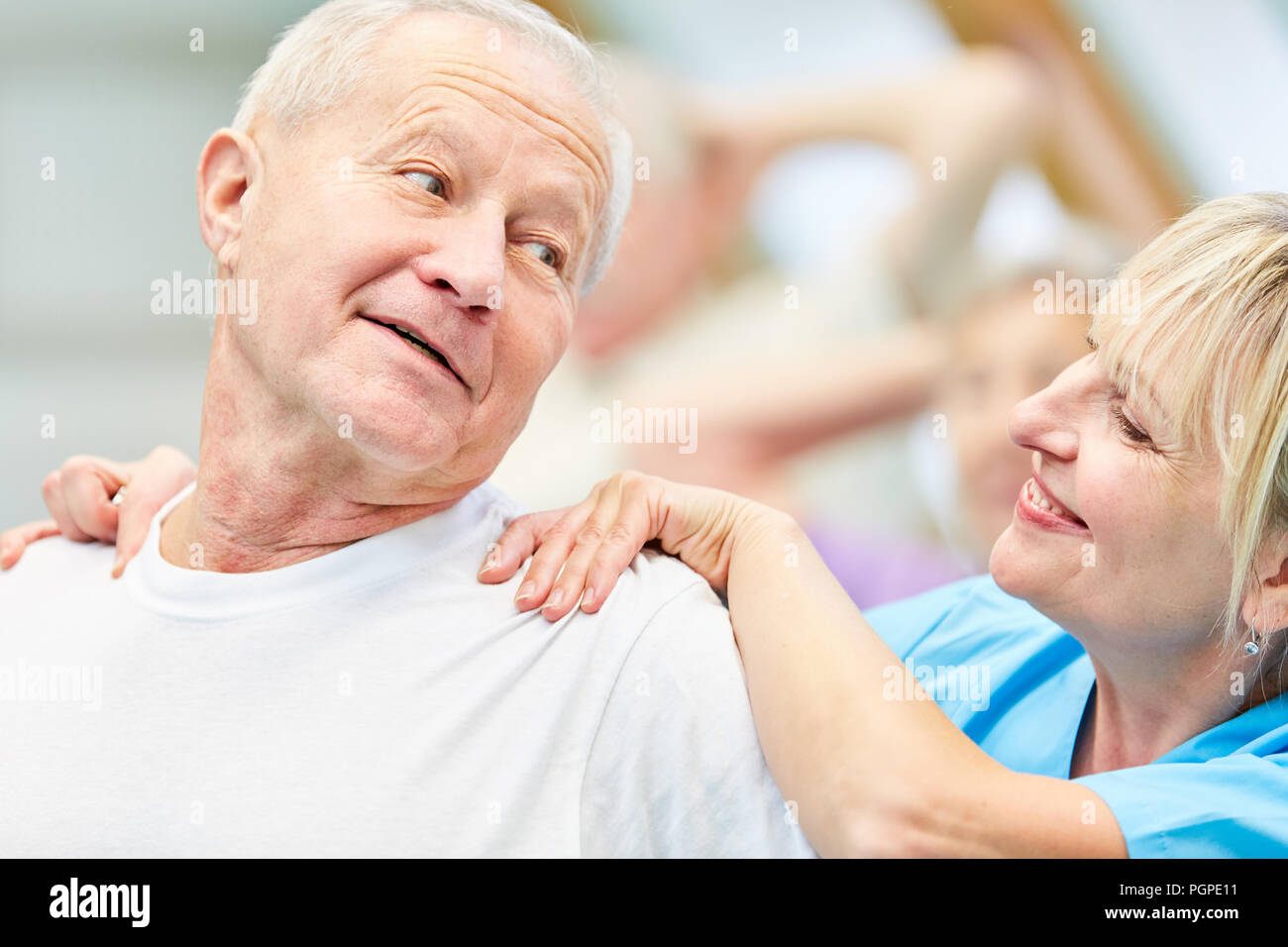 Therapeut gibt älteren Menschen eine Rückenmassage in der Physiotherapie Stockfoto