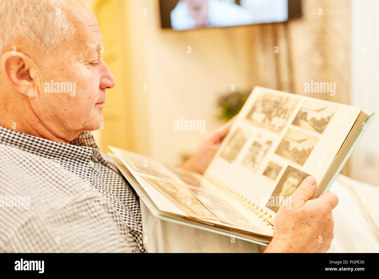 Dementian älterer Mann ist das Betrachten von Fotos in einem Fotoalbum in Pflegeheim Stockfoto