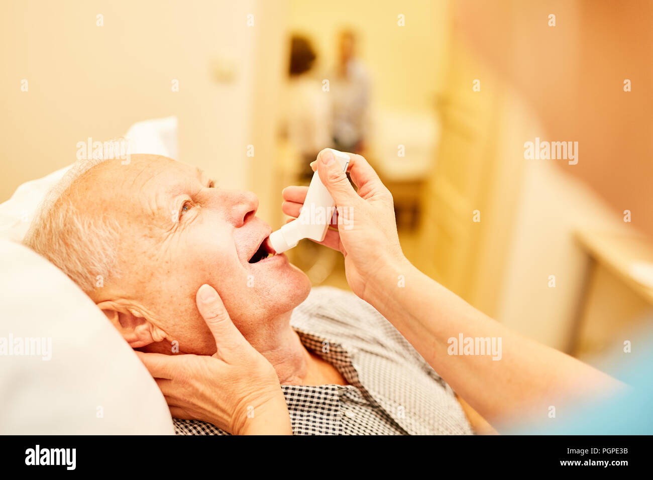 Älterer Mann mit Atemnot wird von der Krankenschwester mit dem Inhalator behandelt Stockfoto