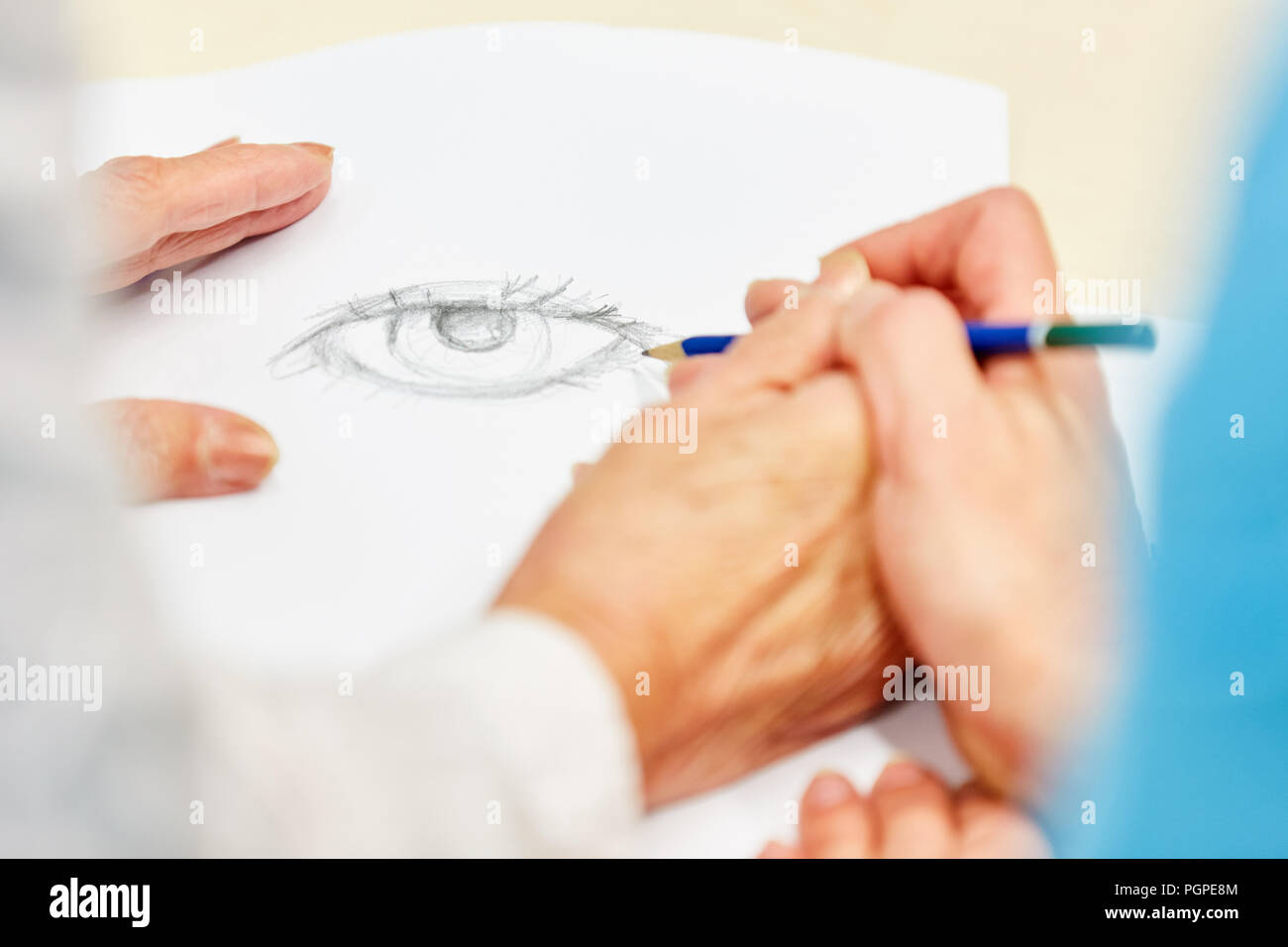 Dementian senior zieht mit Bleistift in kreative Zeichnung Kurs mit Unterstützung Stockfoto