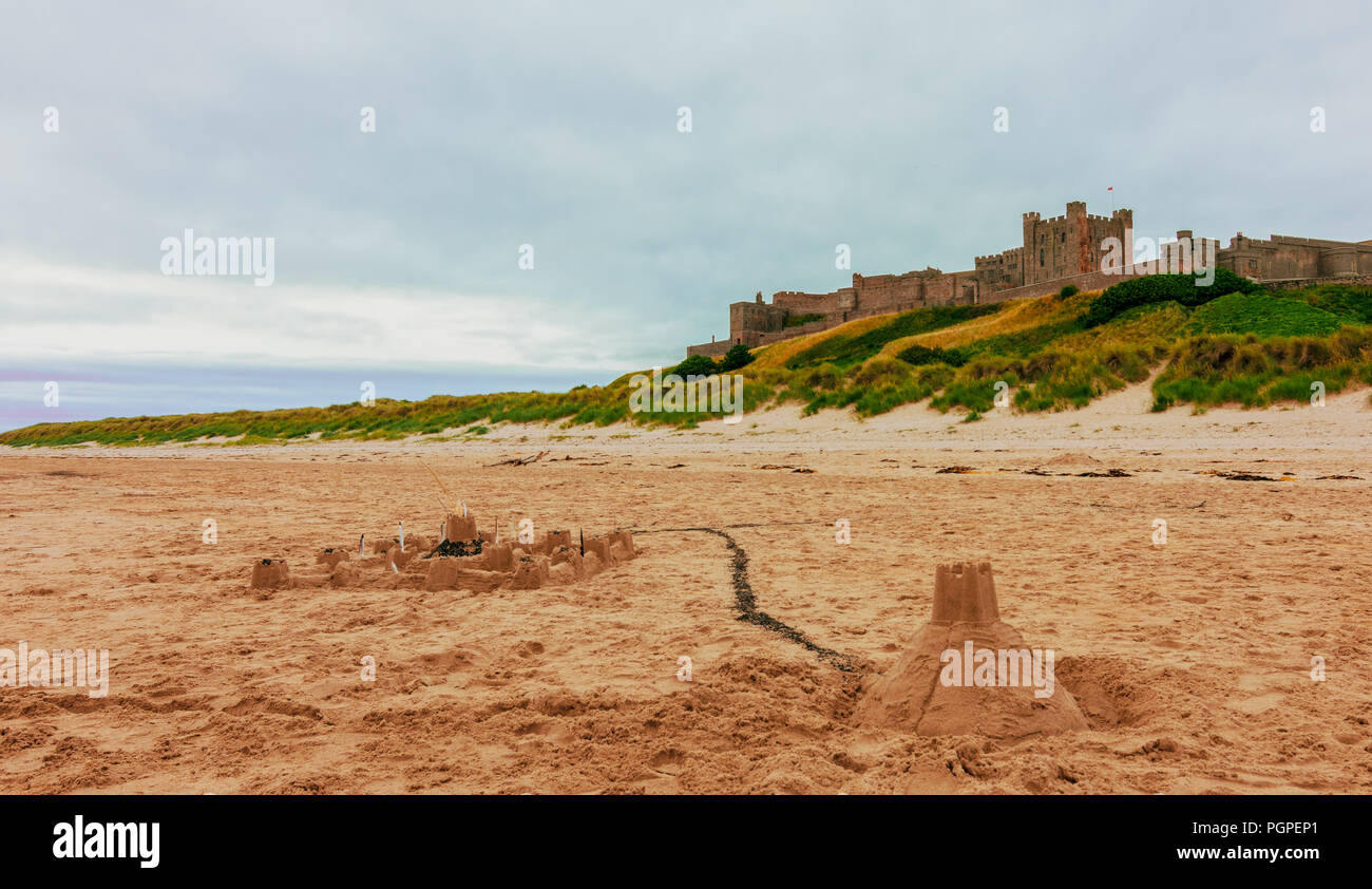 Bamburgh Castle in der Ferne mit sandburgen vor Stockfoto