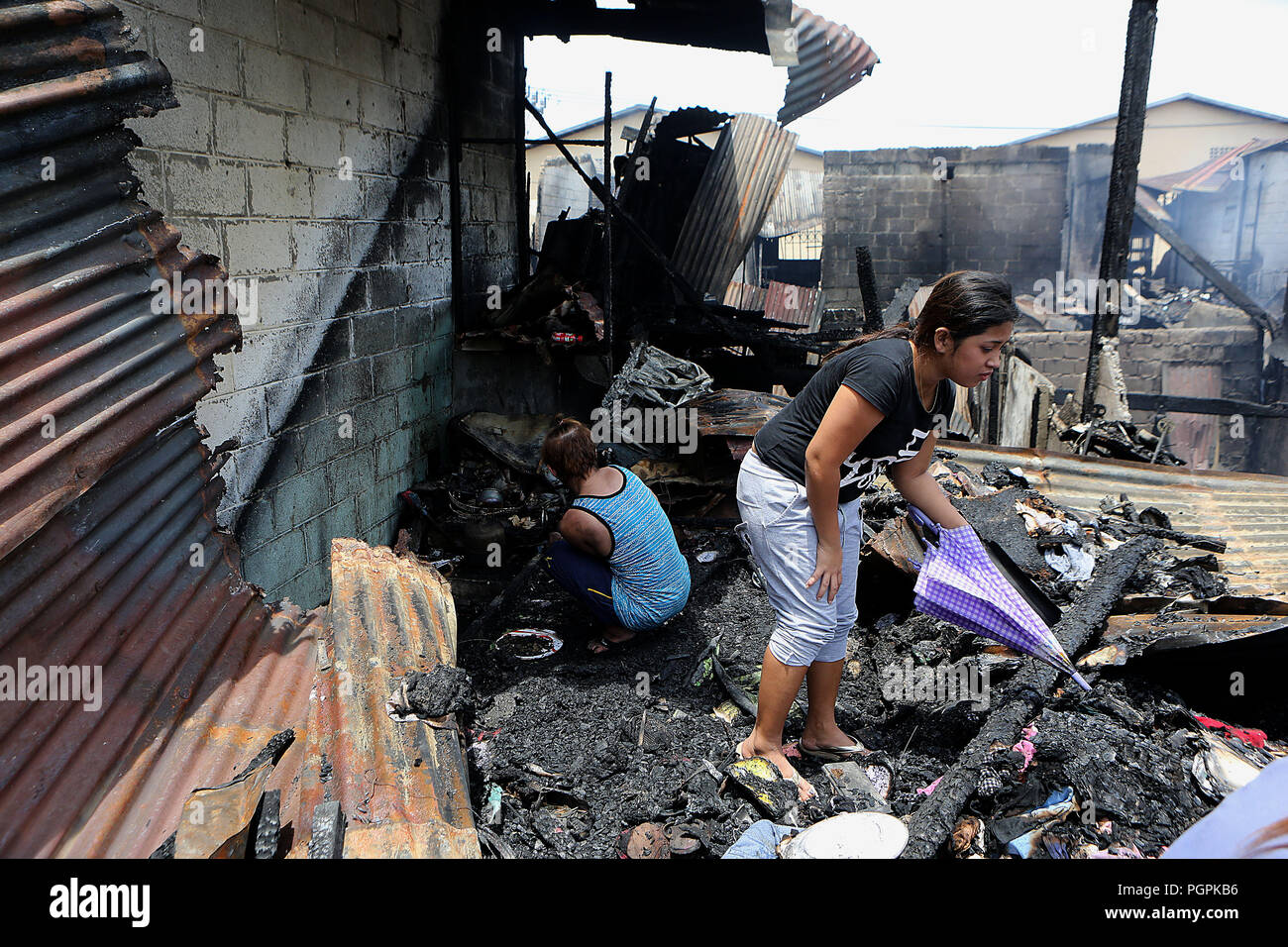 Manila, Philippinen. 28 Aug, 2018. Bewohner suchen für ihre Habseligkeiten durch Trümmer nach einem Brand in Manila auf den Philippinen, Aug 28., 2018. Mindestens fünf Kinder sind gefürchtet, Toten und zwei andere wurden verletzt, als eine Reihe von Häusern in Manilas Tondo Bezirk am Montag morgen dem Erdboden gleichgemacht. Credit: rouelle Umali/Xinhua/Alamy leben Nachrichten Stockfoto