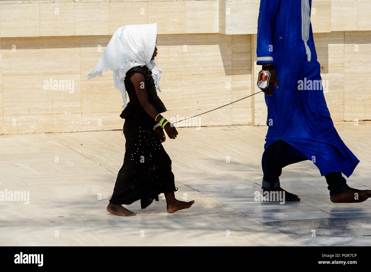 TOUBA eine Enklave, SENEGAL - 26.April 2017: Unbekannter senegalesischen kleines Mädchen Hand in die Hand des Jungen in die Große Moschee von Touba eine Enklave, die Heimat der Mo gebunden Stockfoto