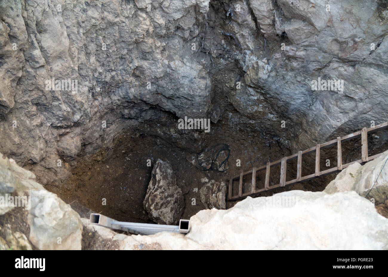 Abstieg in eine Tiefe Grube mit Treppen. Stockfoto