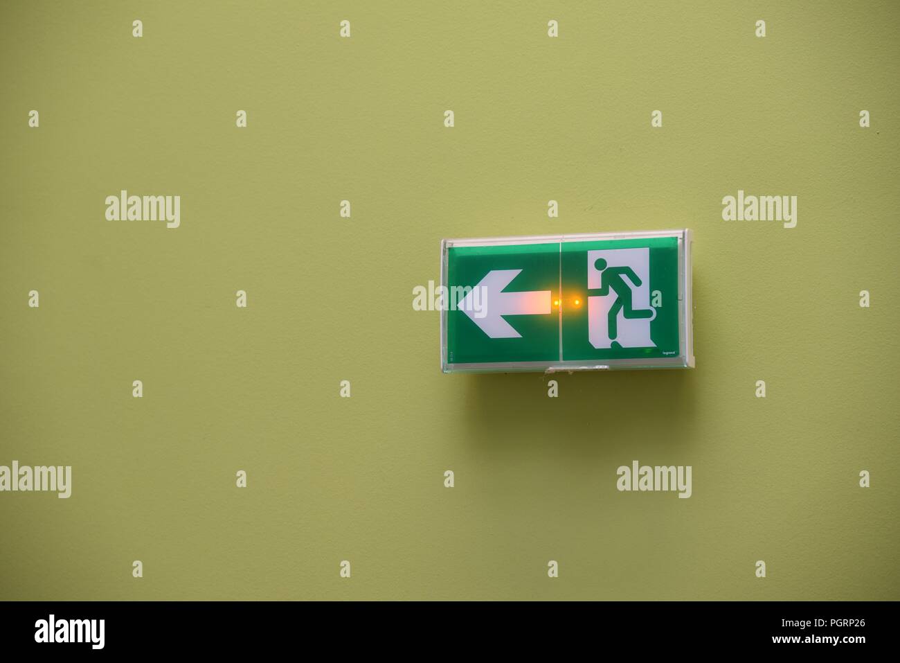 Ausfahrt: eine Ausfahrt mit einem Richtungspfeil und internen Notbeleuchtung auf einer Ebene grün gestrichene Wand Stockfoto