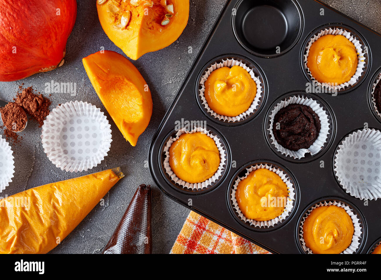 Die Schokolade muffins Kürbis für Halloween Party. Zutaten im Hintergrund, Ansicht von oben, close-up Stockfoto