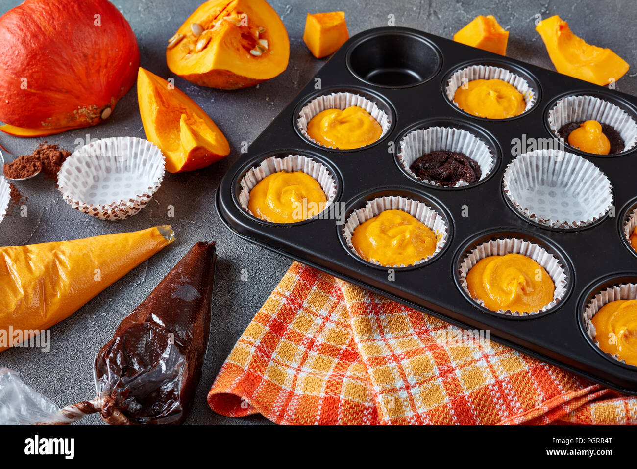Die Schokolade muffins Kürbis für Halloween Party Schritt-für-Schritt. Zutaten auf einer konkreten Tabelle, Ansicht von oben Stockfoto