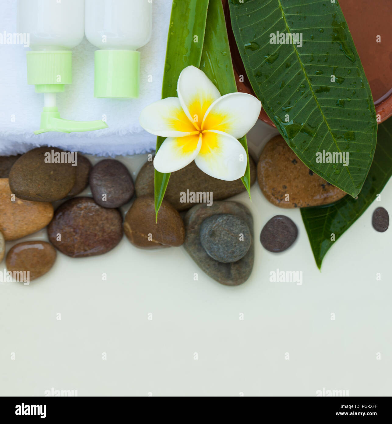 Spa, Wellness oder Hintergrund mit weißer Bettwäsche, tropische Blätter, Blumen, Körper und Gesicht pflege Werkzeuge und Zubehör auf weißem Hintergrund, Ansicht von oben. Stockfoto