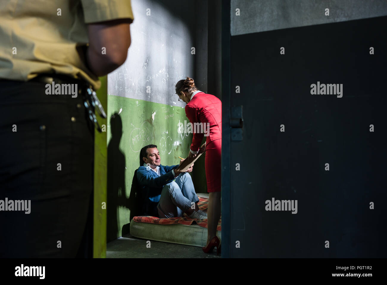 Damen Rechtsanwalt Besuch einer jungen Insassen in eine veraltete Gefängniszelle Stockfoto