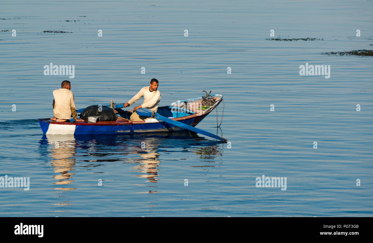 Ägyptische Männer im Boot mit Rudern im Morgenlicht mit Wasser Reflexionen, Nil, Ägypten, Afrika Stockfoto