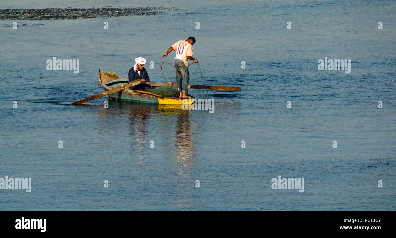 Ägyptische Männer im Boot mit Rudern fischen mit Netz im Morgenlicht mit Wasser Reflexionen, Nil, Ägypten, Afrika Stockfoto