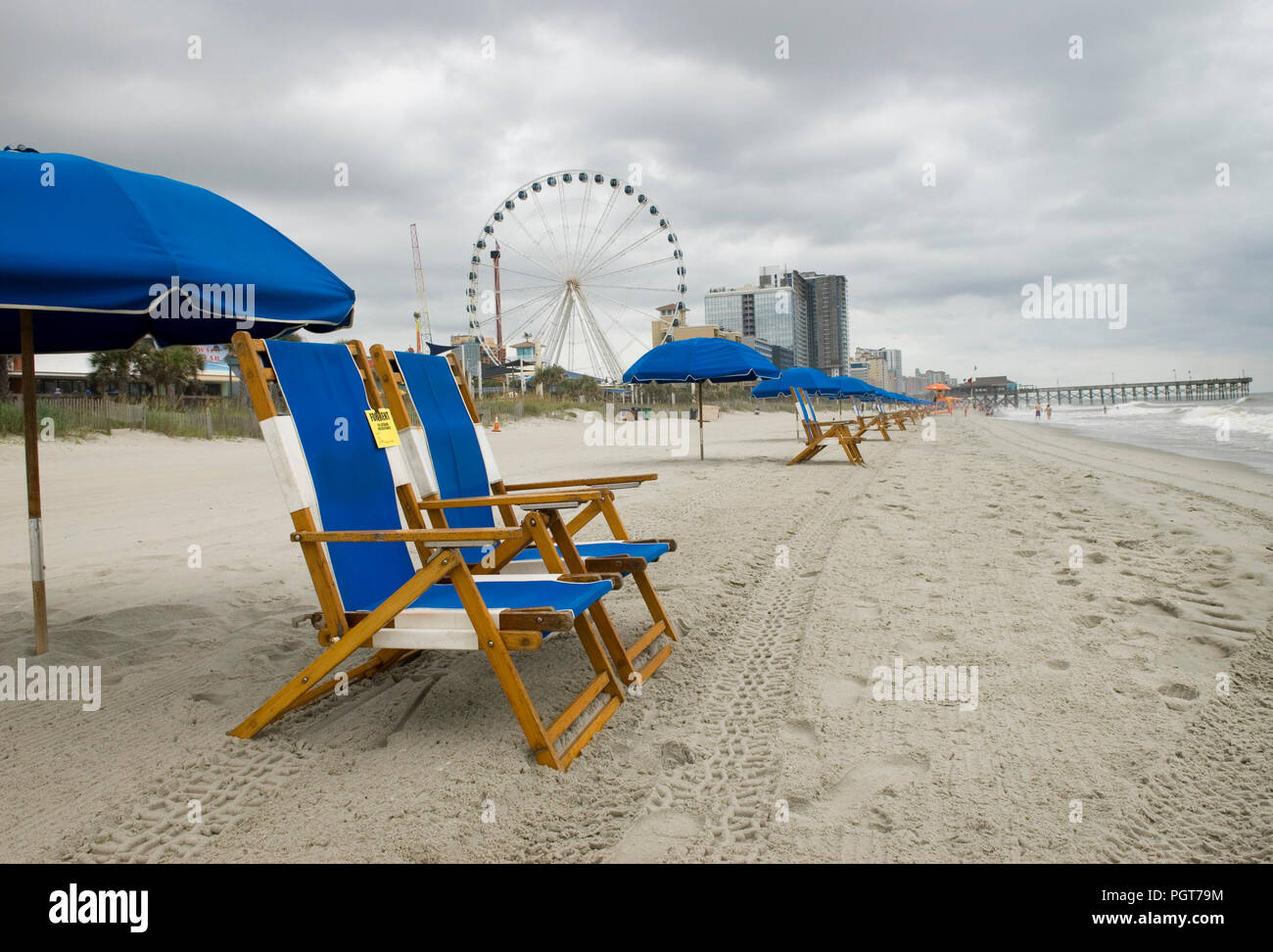 Leeren blauen Stühlen und Sonnenschirm Linie des Meeres auf ein trüber Tag in Myrtle Beach, SC USA Stockfoto