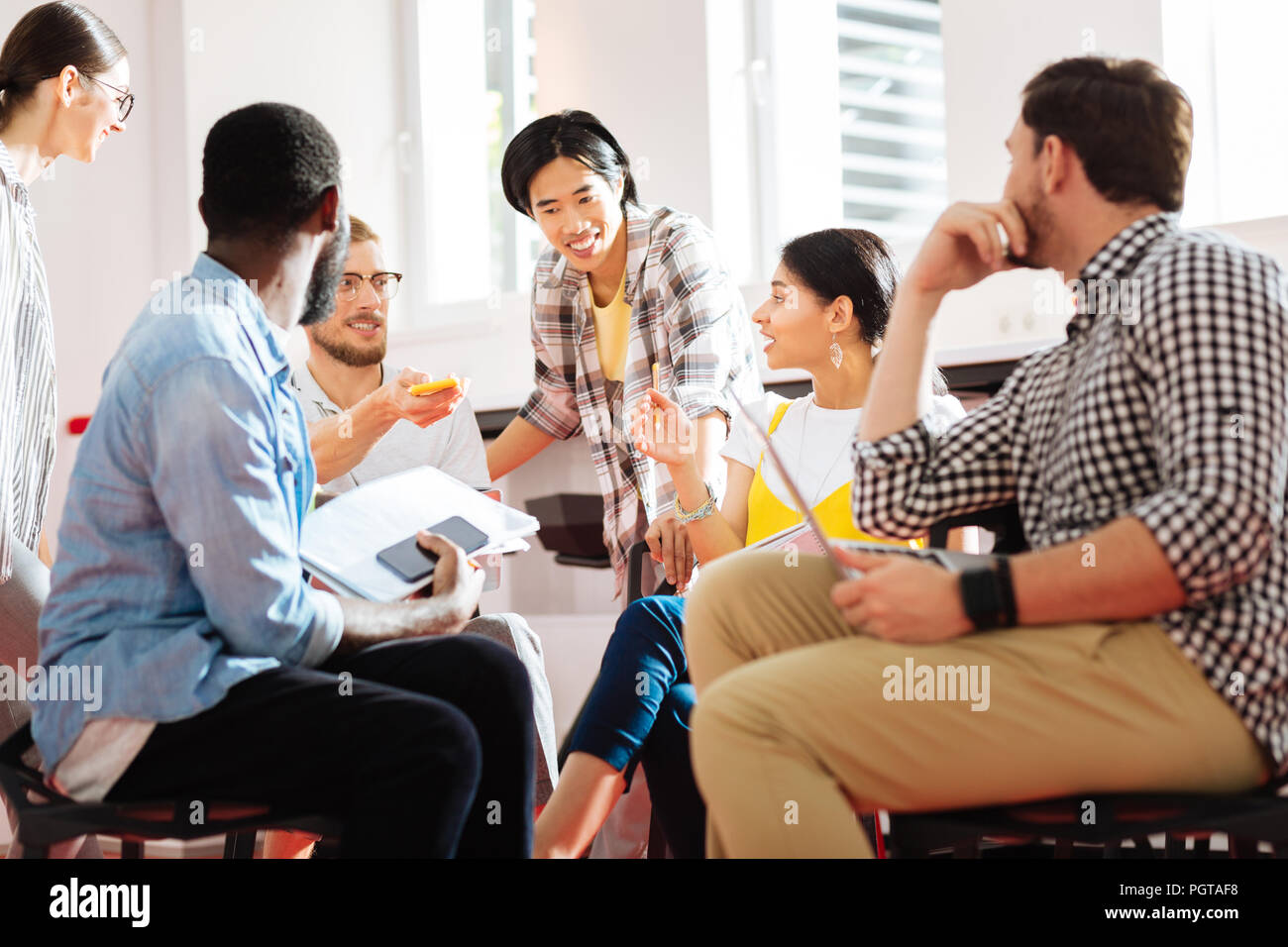 Positive Lehrer lehnte sich an die Studenten und Gefühl mit ihrer Arbeit zufrieden Stockfoto