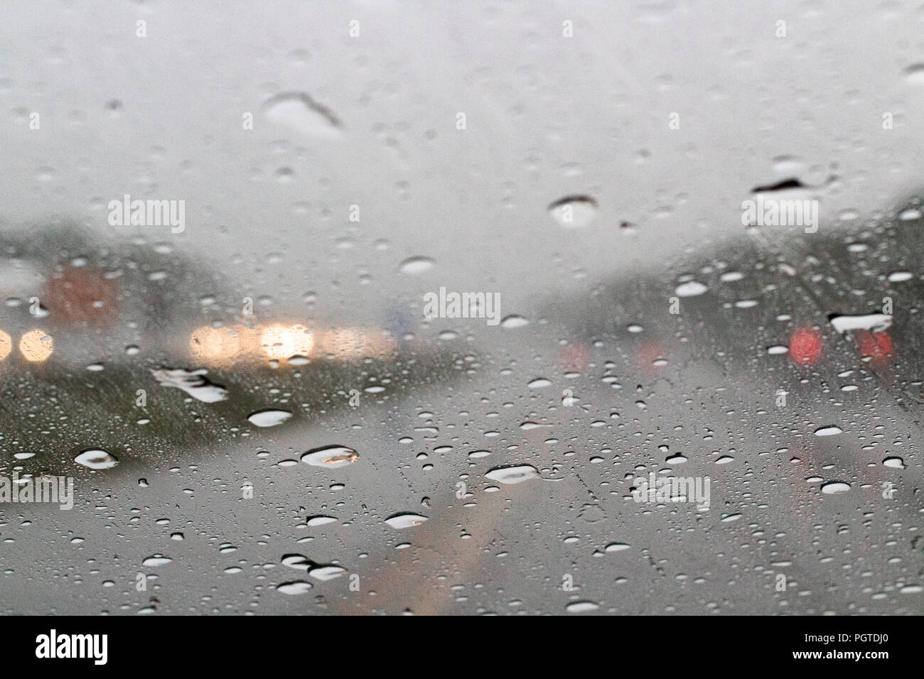 Regen Tropfen schoss durch ein Auto Windschutzscheibe auf der Autobahn Stockfoto