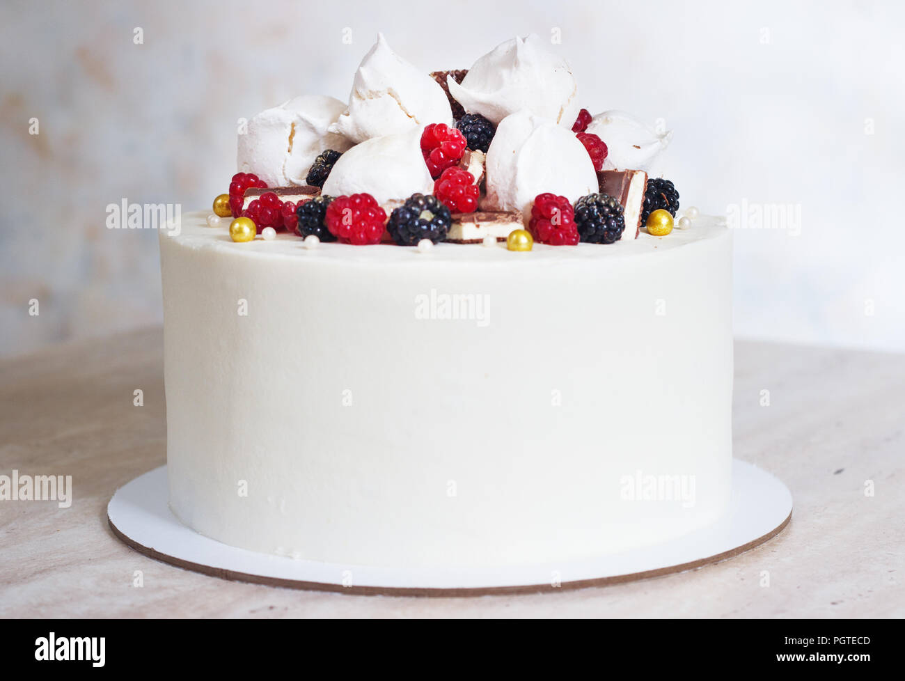 Weiß festliche Kuchen mit Baiser und Beeren. Stockfoto