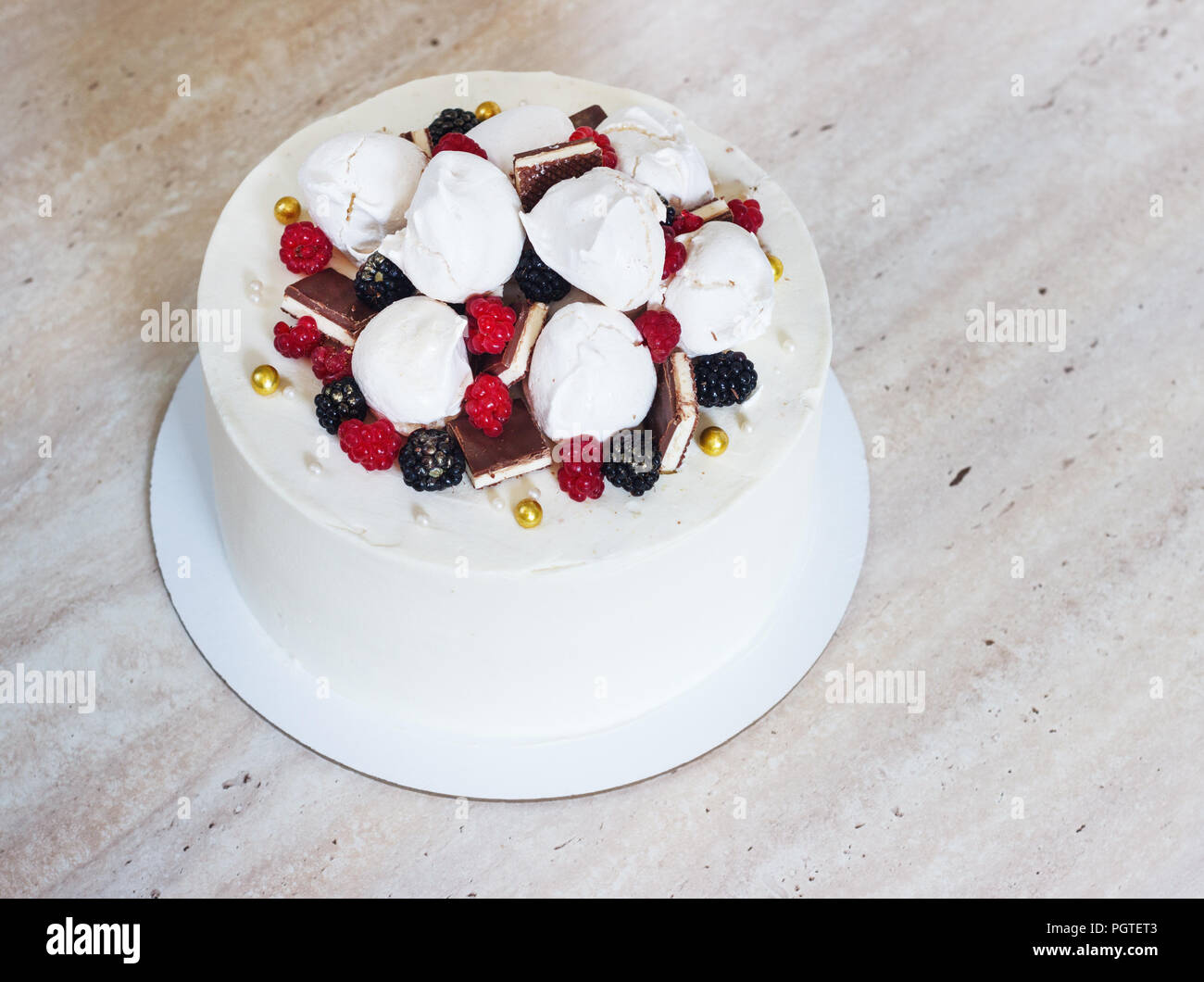Weiß festliche Kuchen mit Baiser und Beeren. Stockfoto