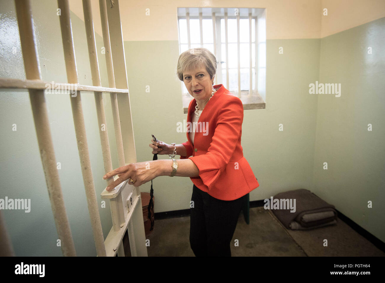 Premierminister Theresa May tritt in eine Zelle auf Robben Island Kapstadt, Südafrika, die politischen Gefangenen Nelson Mandela, der Präsident von Südafrika, und wer dort war für 18 Jahre untergebracht. Stockfoto