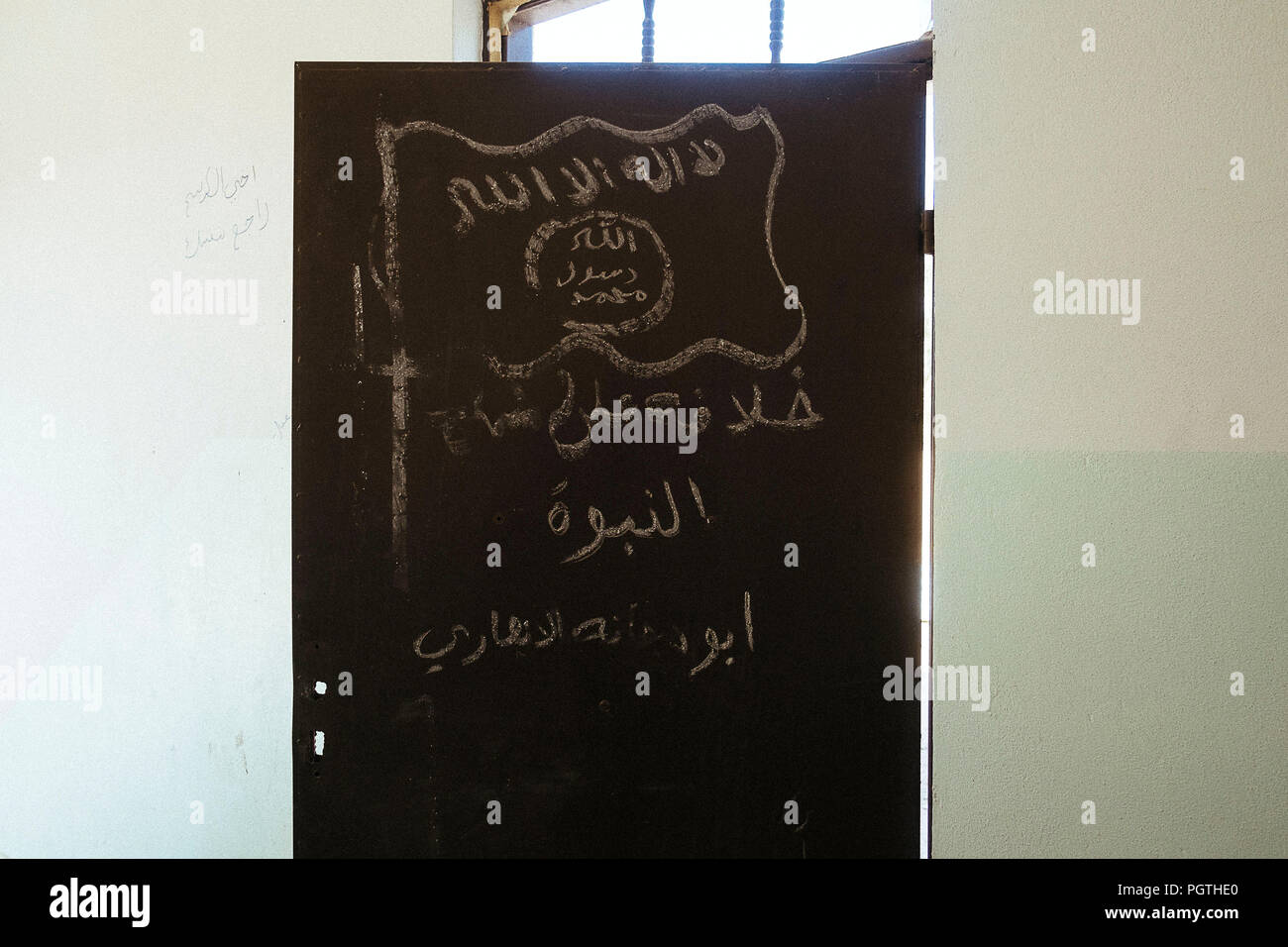 ISIS Flagge und Kreide in einem Gebäude in der christlichen Stadt Qaraqosh von ISIS zerstört geschrieben Stockfoto