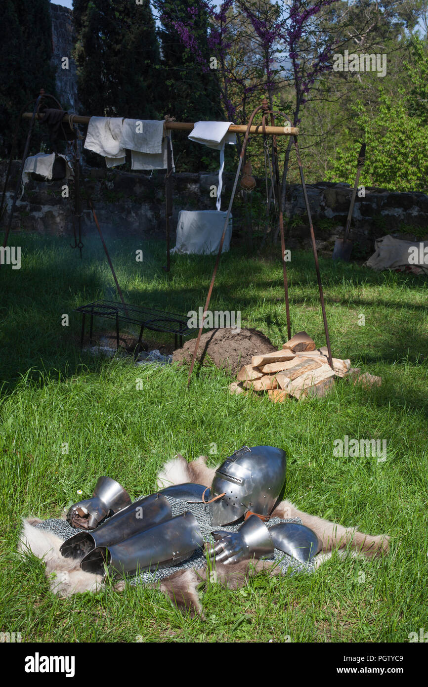 Ritter Rüstung auf der tierischen Haut gestapelt neben dem offenen Kamin in der mittelalterlichen Festival' Al cospetto dei Conti di Gorizia 2018' Stockfoto