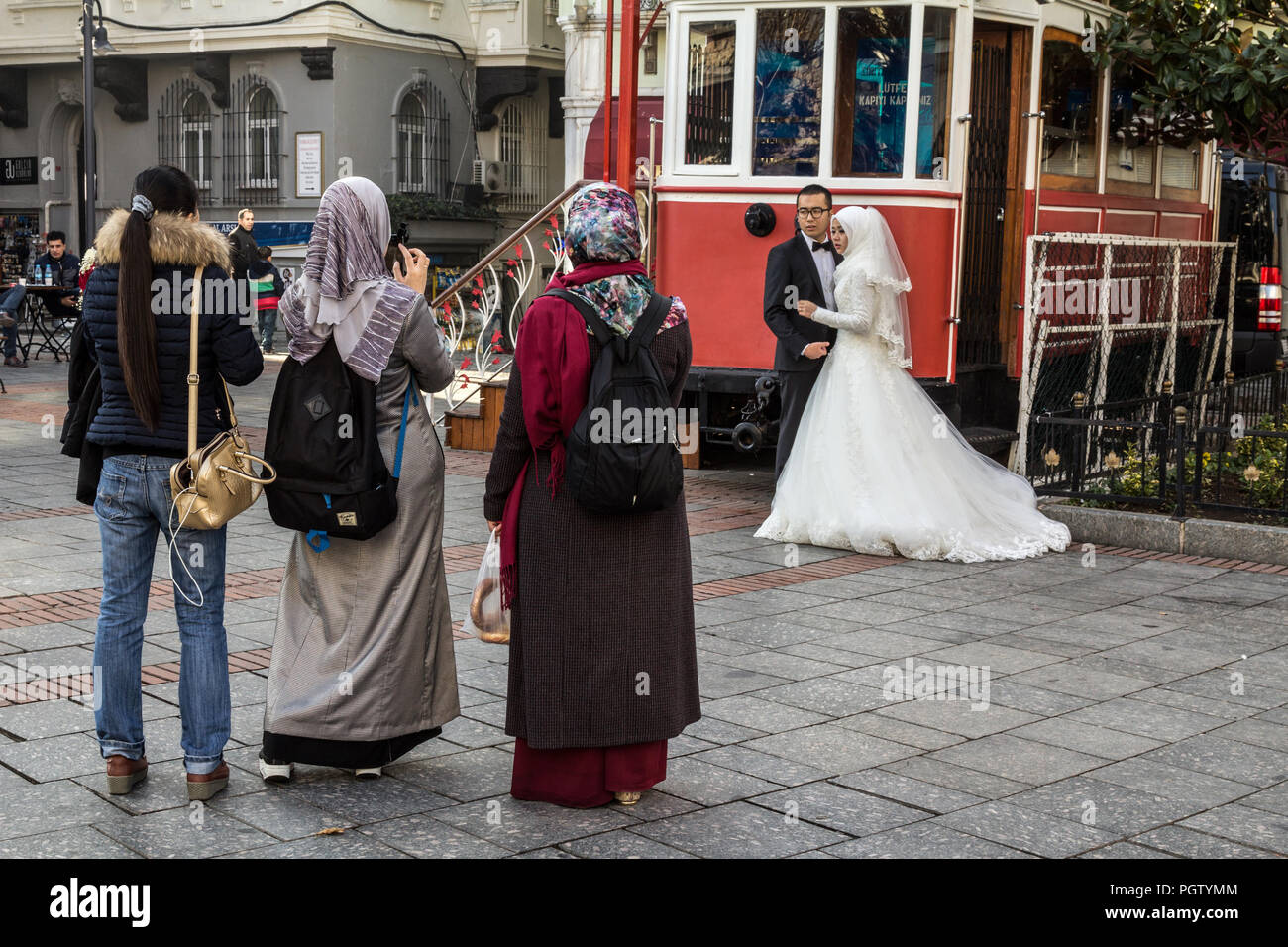 ISTANBUL, Türkei - 27 Dezember, 2015: Die Menschen tragen islamische Schal, Hochzeit Bilder mit Smartphones eines neu verheiratete Paare, die Braut weari Stockfoto