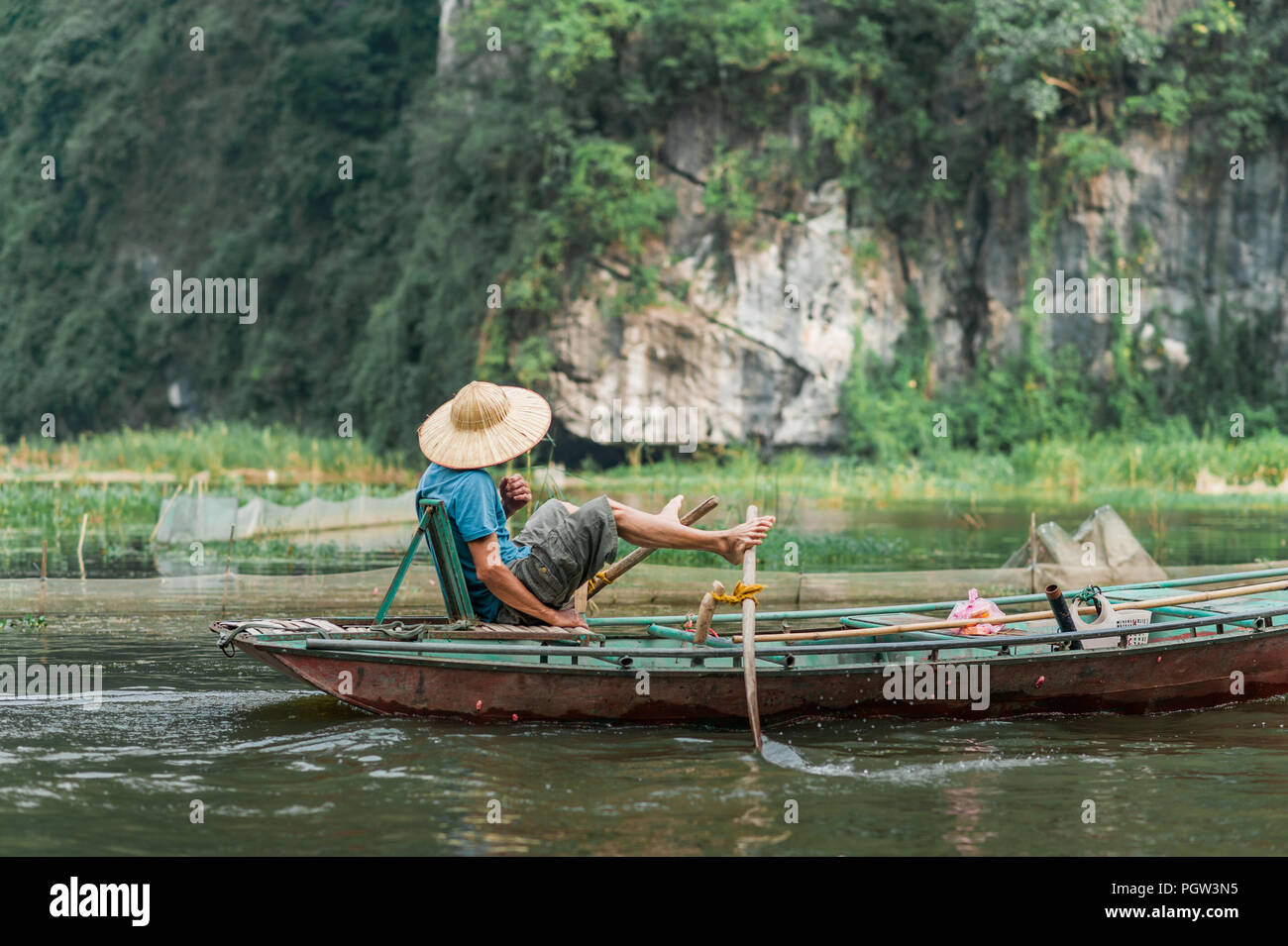Lokale Mann in einem Reis hat Rudern mit dem Boot entfernt von Vung Straßenbahn Pier. Traditionelle Paddle - Bootsfahrt können die Touristen die Ngo Dong Fluss zu schätzen wissen. Stockfoto