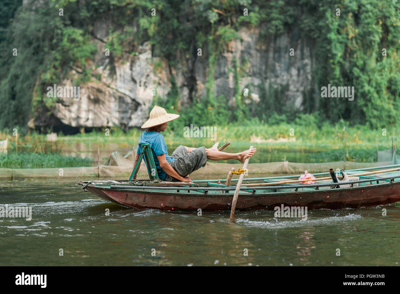 Lokale Mann in einem Reis hat Rudern mit dem Boot entfernt von Vung Straßenbahn Pier. Traditionelle Paddle - Bootsfahrt können die Touristen die Ngo Dong Fluss zu schätzen wissen. Stockfoto