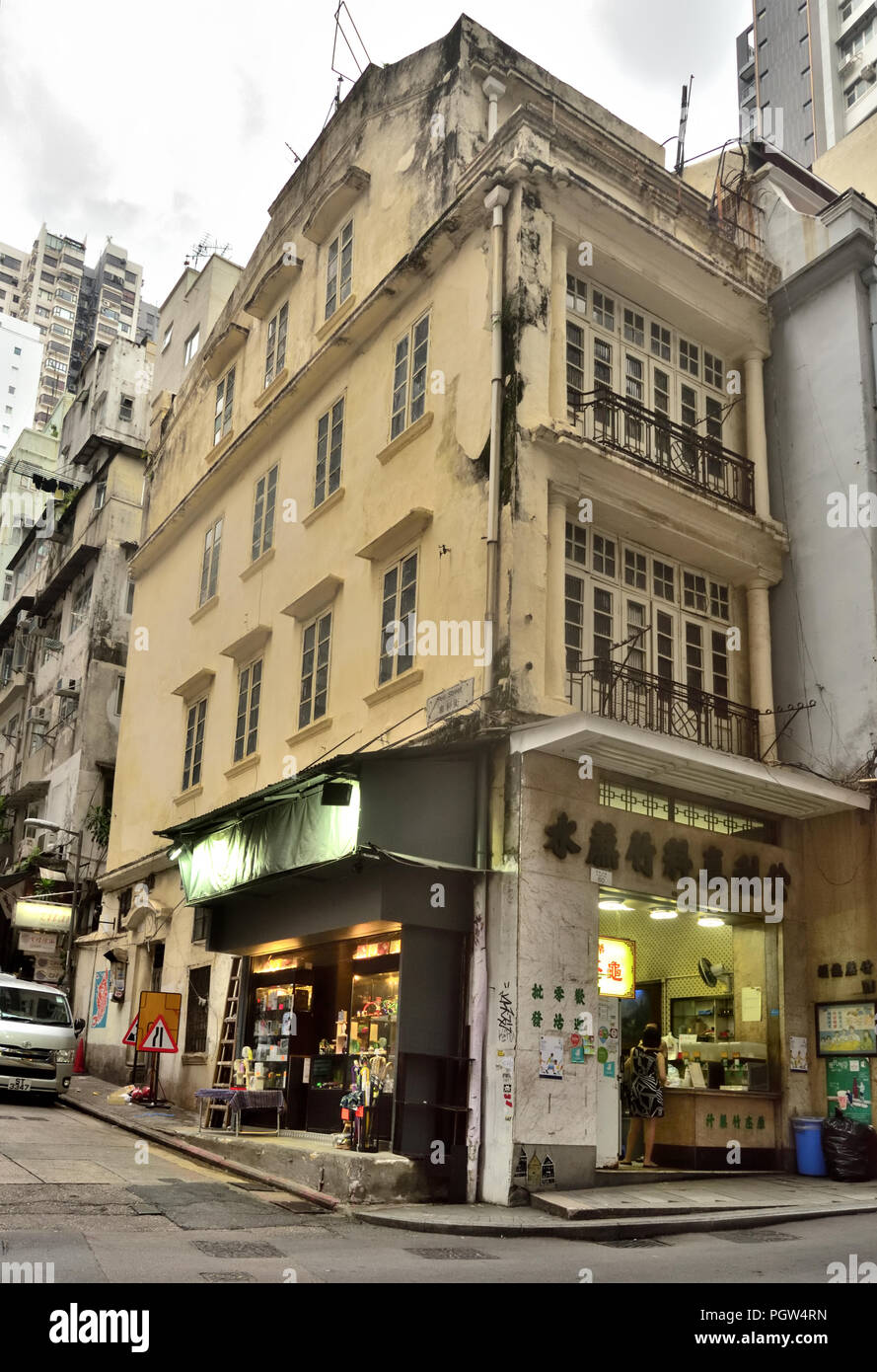 Kleines Geschäft, das Zuckerrohrsaft und Getränke auf Straßenebene eines alten Gebäudes an der Skipiste, Central, Hongkong, verkauft Stockfoto