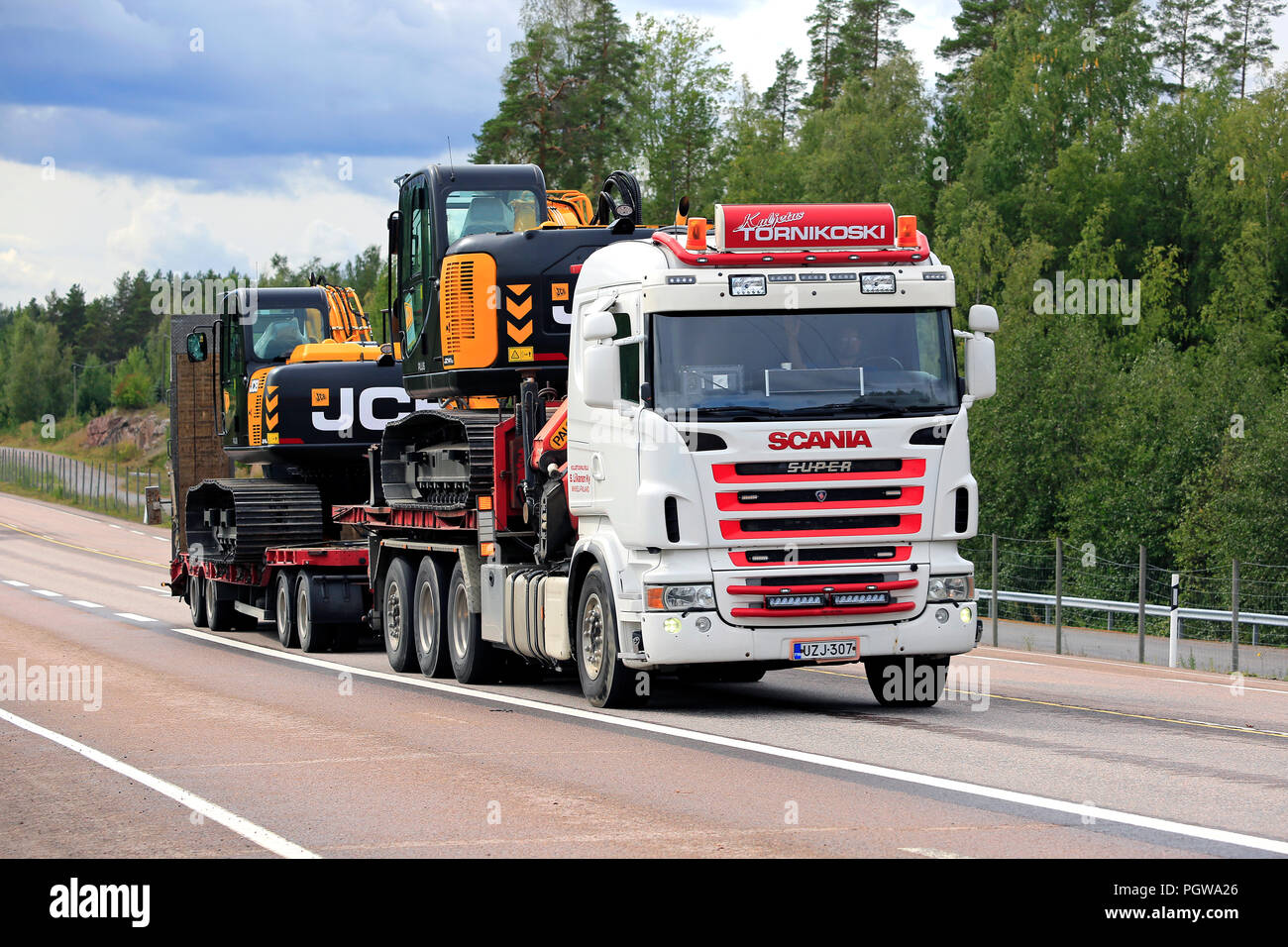ORIVESI, Finnland - 27. AUGUST 2018: Super Scania Truck von kuljetus Tornikoski Oy Hols zwei neue Mid-size JCB Bagger entlang der Autobahn im Spätsommer. Stockfoto