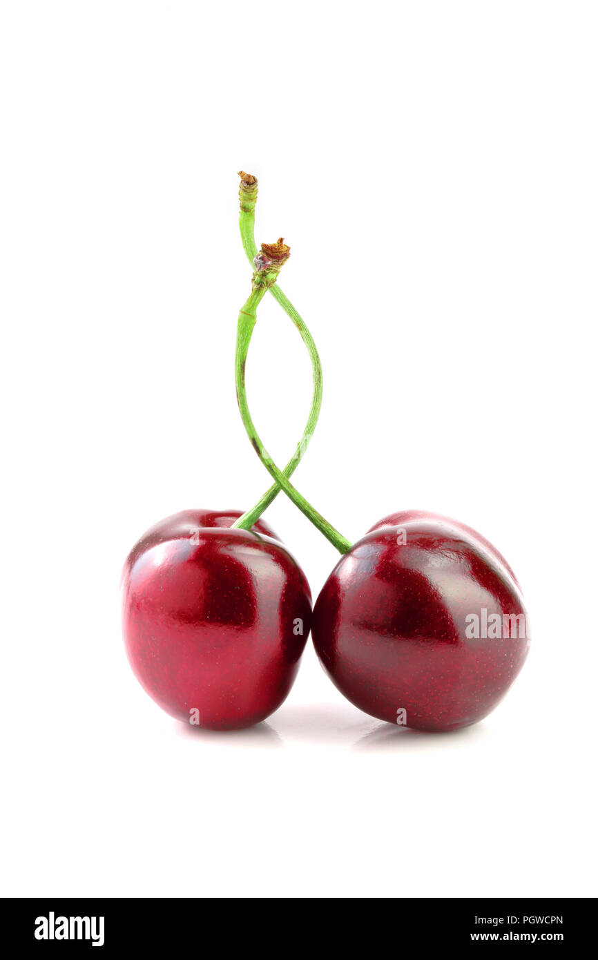 Süße rote Kirschen auf weißem Hintergrund Makro isoliert. Stockfoto