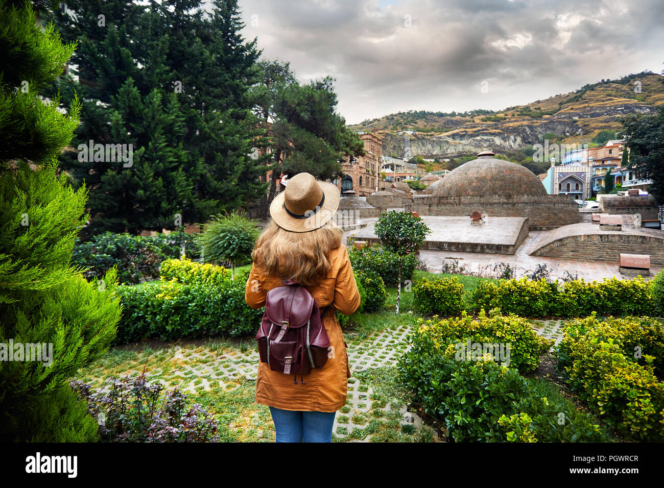 Schöne Frau in braunen Hut und Jacke auf der Kuppel des Öffentlichen Schwefelsäure Badewanne Bezirk im Zentrum von Tiflis, Georgien Stockfoto