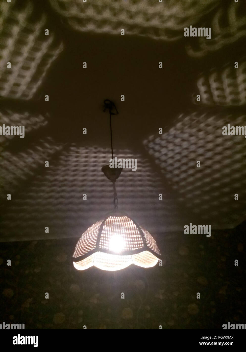 Eine beleuchtete schäbig retro Lampe, unerwartete und gruselige Schatten mustern auf den Innenraum. Stockfoto