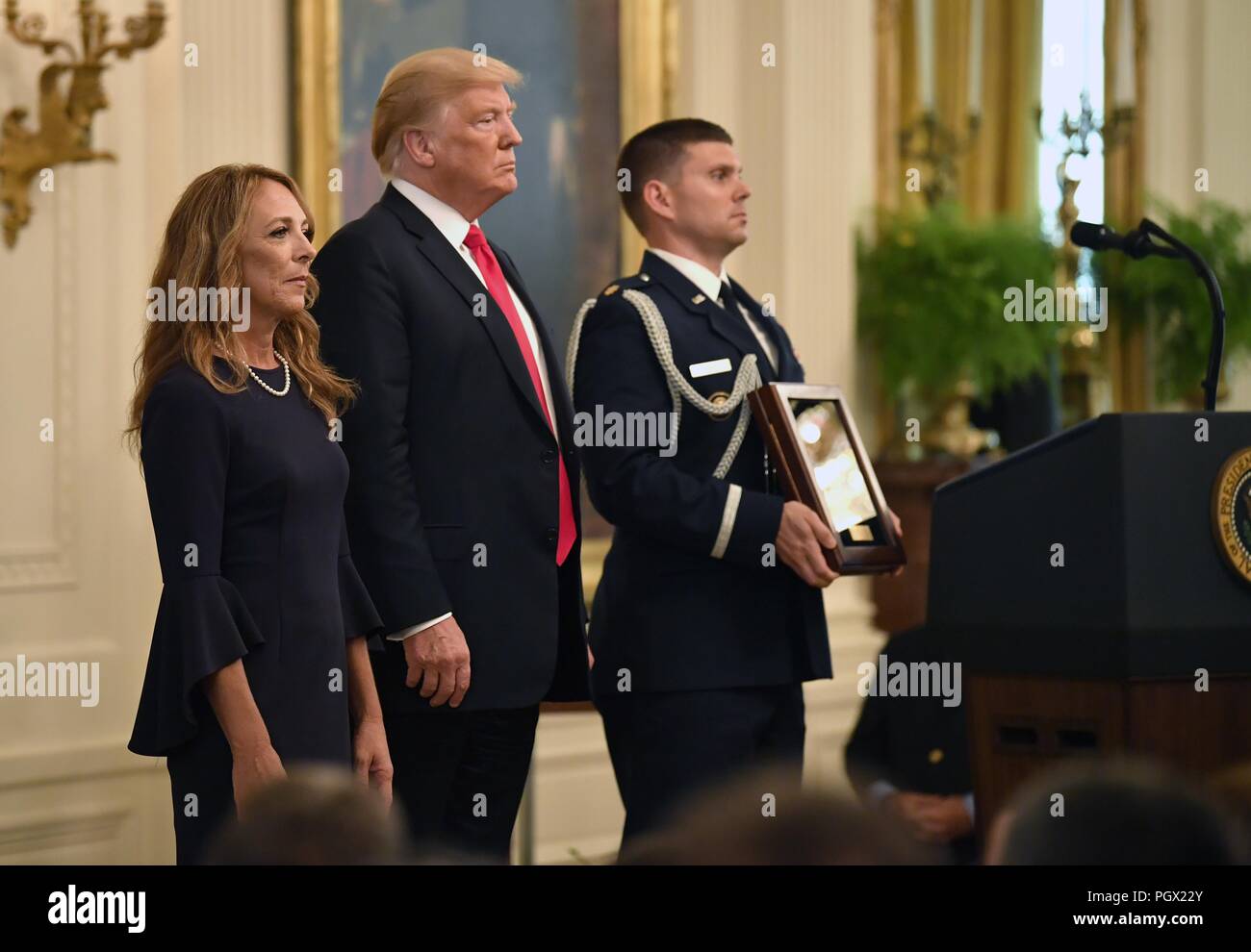 Präsident Donald J. Trumpf und Valerie Nessel, der ehegatte der US Air Force Tech, 22. August 2018. Sgt. John Chapman stehen, als das Zitat wird vor Erhalt der Ehrenmedaille, White House, Washington, D.C. Bild mit freundlicher Genehmigung Wayne Clark/Sekretär der Air Force Public Affairs. () Stockfoto