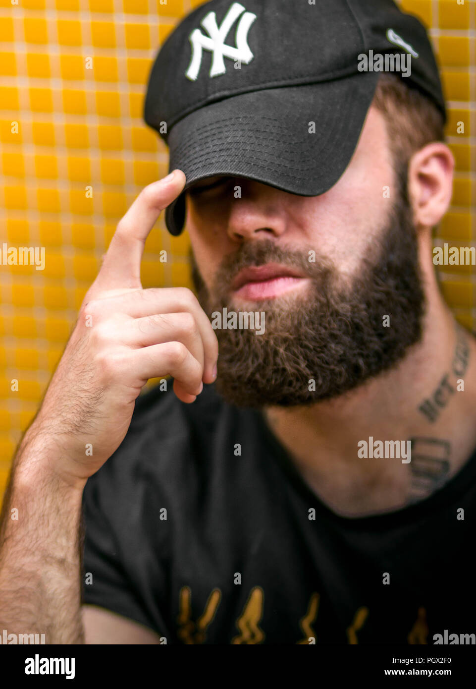 Portrait einer jungen Hipster tätowierten Mann mit New York Yankees hat Stockfoto