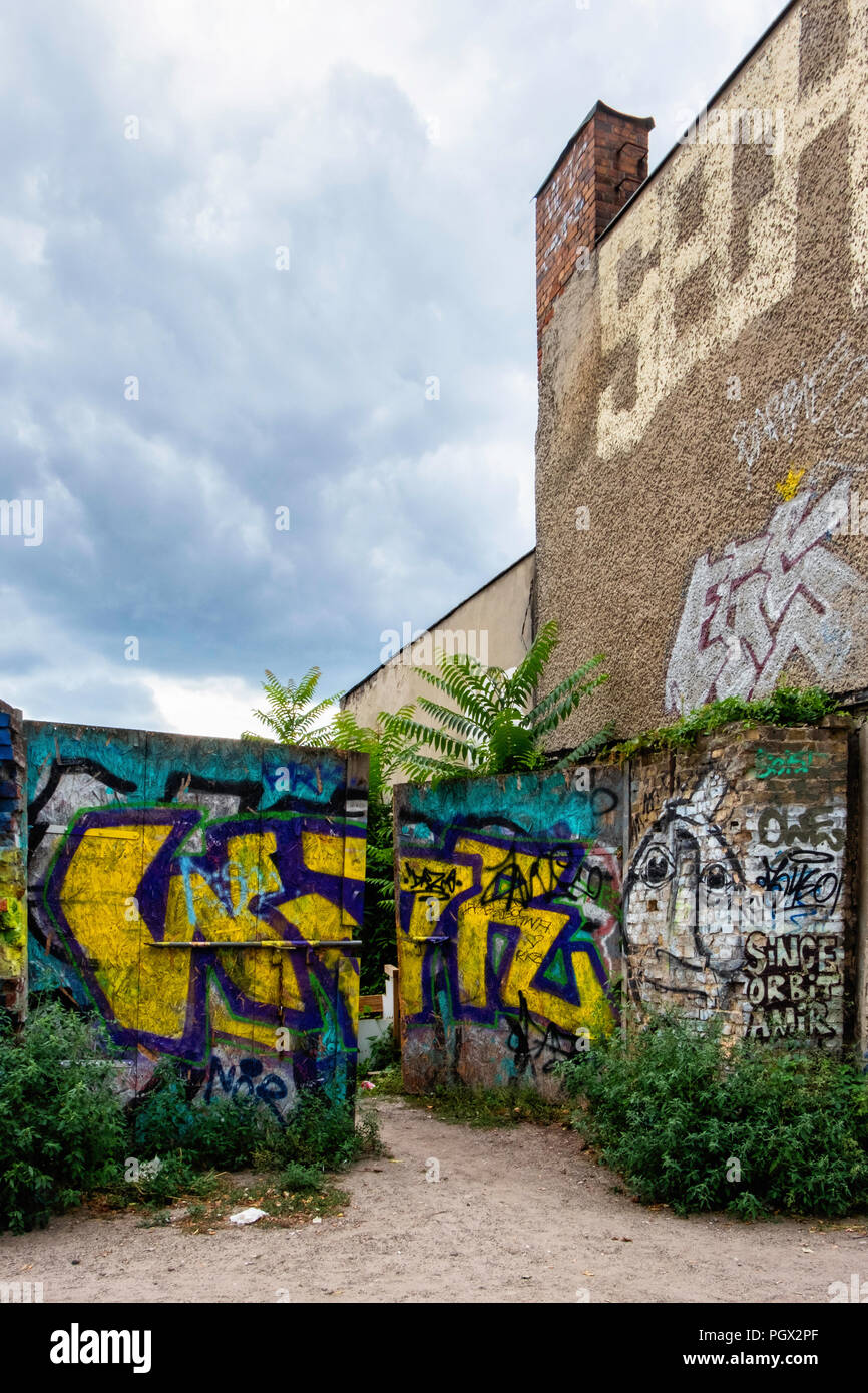 Berlin, Friedrichshain. Blick auf die Straße der alten Gebäude und Mauer in Graffiti und Street Art abgedeckt Stockfoto