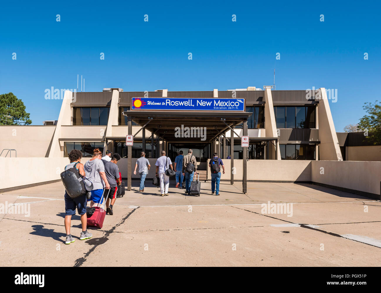 Roswell, New Mexiko, USA, Passagiere deplane außerhalb und Flughafen Terminal Gebäude unter einem Willkommen bei Roswell Zeichen eingeben. Stockfoto