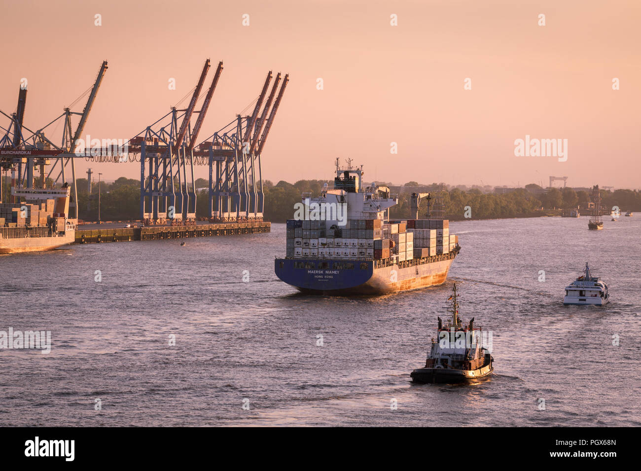 Containerfrachter, Ladung Schiffes aus dem Hafen von Hamburg an der Elbe bei Dämmerung, Hamburg, Deutschland Stockfoto